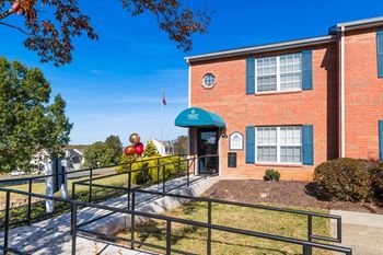 A red brick building with a green awning and a flag on top.